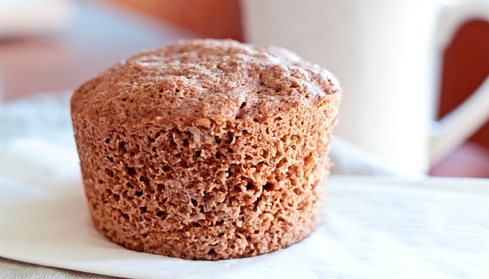 A delicious lectin-free muffin containing flaxseed (one of the best prebiotic foods) sitting on a white surface.