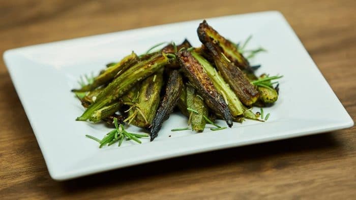 A plate of Plant Paradox okra lectin-blocking chips sitting on a white plate on a wooden table