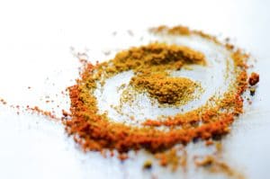 Turmeric root extract Yellow turmeric powder in a circular pattern on a white surface