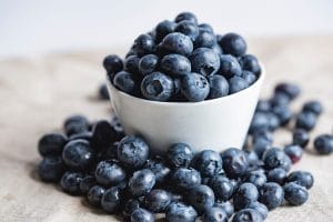 White bowl of blueberries on a table