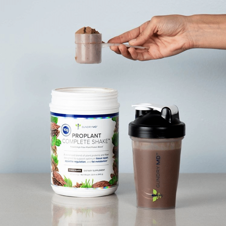 Gundry MD holding a scoop of ProPlant Complete Shake powder with a full shaker bottle