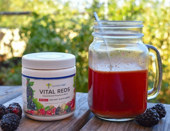 Vital Reds container next to a mason jar with red juice in it