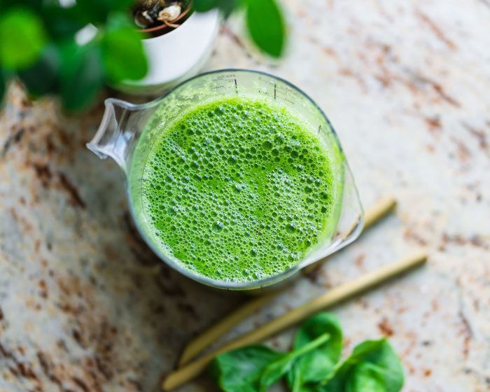 A green Plant Paradox smoothie with green bananas - one of the best prebiotic foods - sitting on a marbled countertop